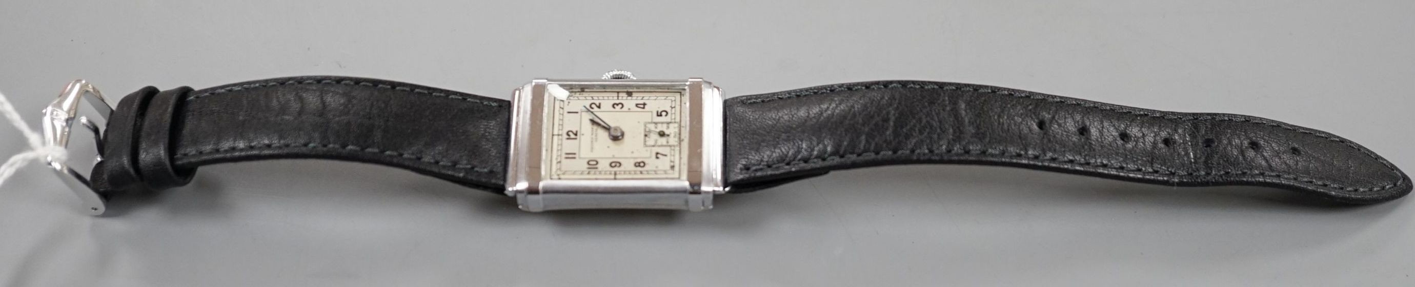 A gentleman's steel Record Watch Co, manual wind wrist watch, on associated leather strap.